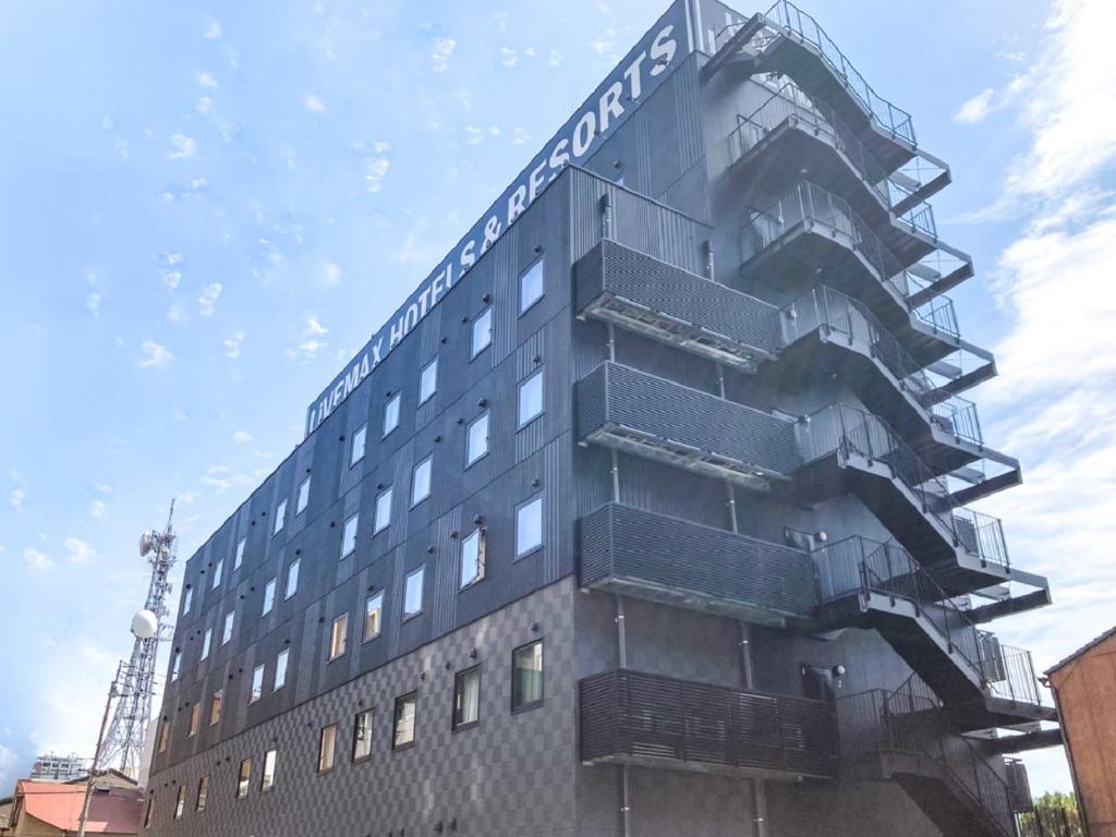 a tall building with a sign on the side of it at HOTEL LiVEMAX Takamatsu Eki Mae in Takamatsu