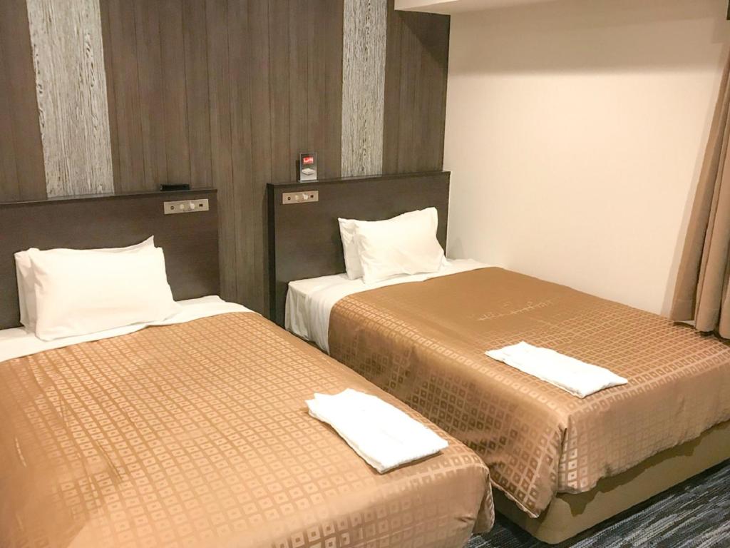 Postel nebo postele na pokoji v ubytování HOTEL LiVEMAX Takamatsu Eki Mae