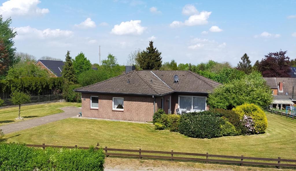 een huis met een grote tuin met een hek bij Ferienhaus No.10 in Hemmoor