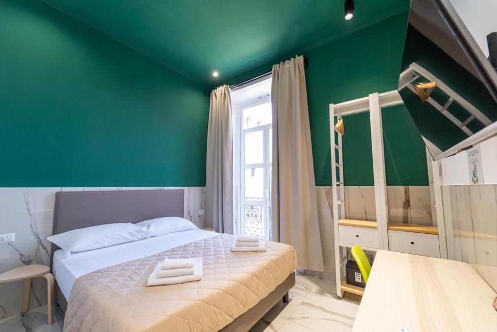 Un dormitorio con una pared verde y una cama en P.C. Boutique Medina H. Napoli Centro, by Clapa Group en Nápoles