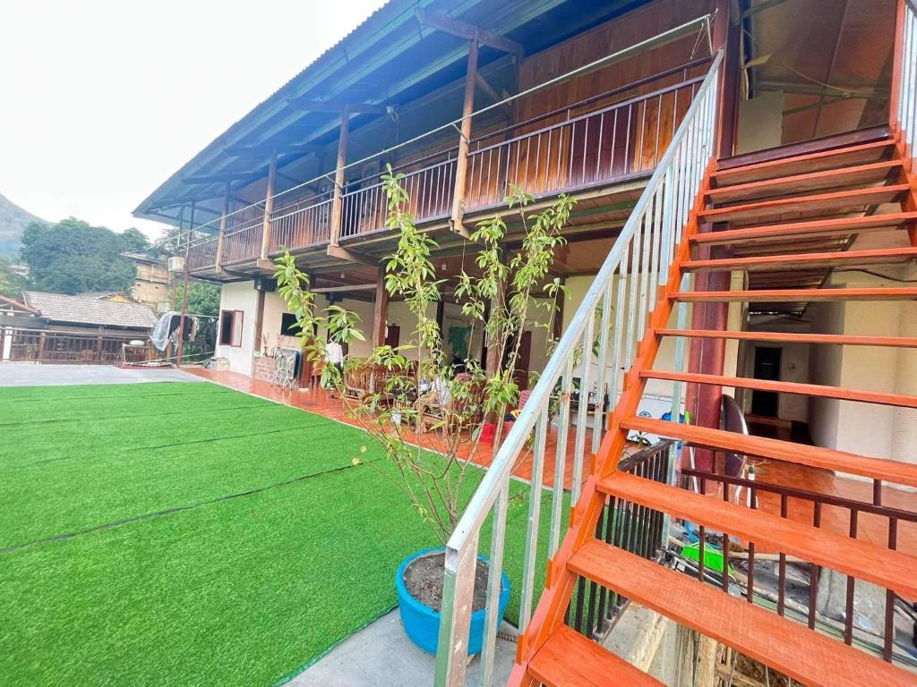 a house with a staircase and a green lawn at Trần Thực homestay-Ba bể in Ba Be