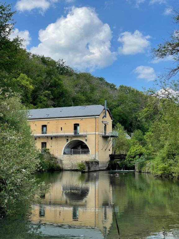 un edificio a orillas de un río en Le Moulin de cherré gîte bleu, en Aubigné-Racan