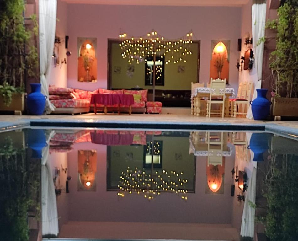 una sala de estar con reflejo de una piscina en Villa Marrackech Sbai en Oubadine