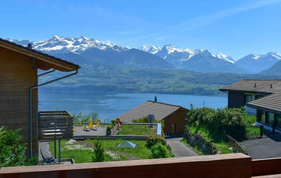 uma vista para um lago e montanhas a partir de uma casa em Panorama Boutique Apartment with complimentary Spa access at Solbad Hotel em Sigriswil