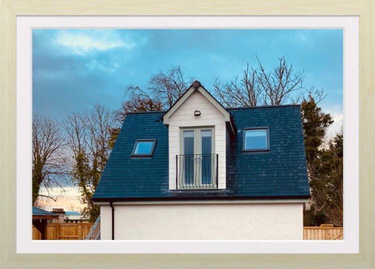 een huis met een blauw dak en een balkon bij 'Wardlaw View' Luxury studio apartment with stunning view in Kirkhill