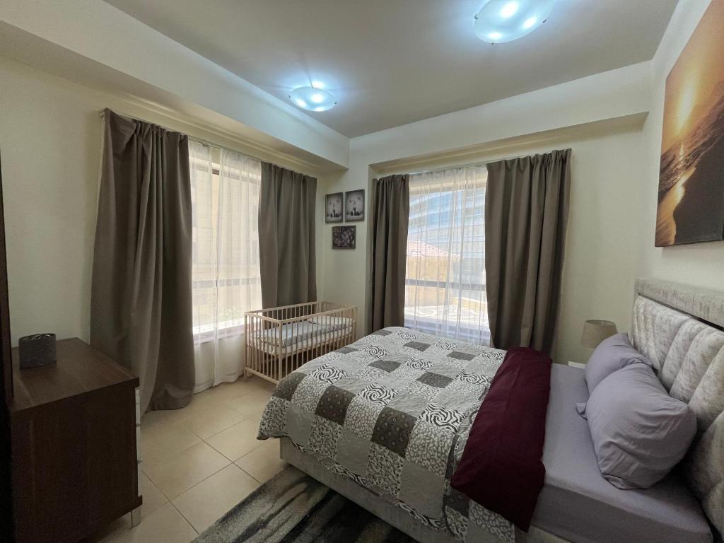 a bedroom with a bed and a window with a crib at 1 Bedroom in Jumeirah Beach Residence Dubai in Dubai