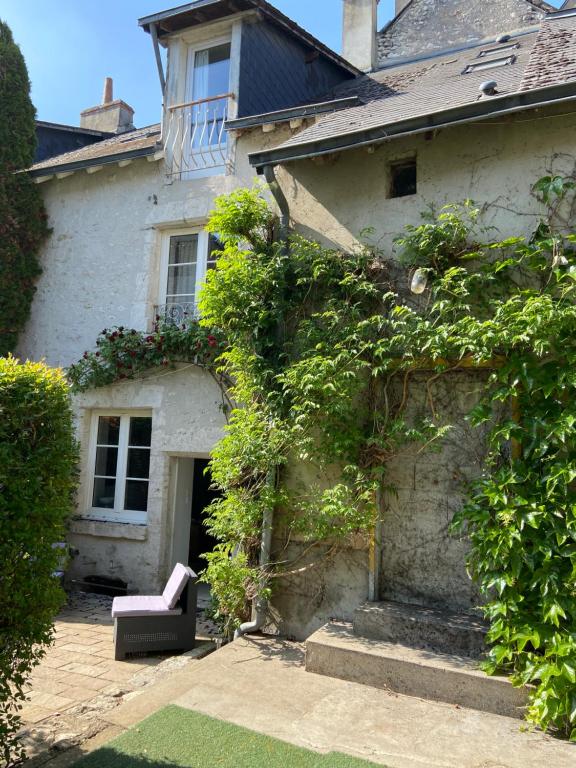 a house with a bench sitting outside of it at Gîtes « le clos saint Hilaire » in Mer