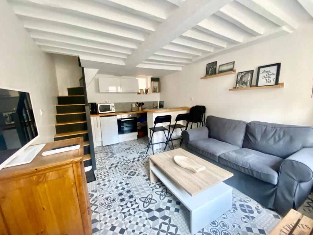 een woonkamer met een bank en een tafel bij Charmante maison au coeur de Villerville in Villerville