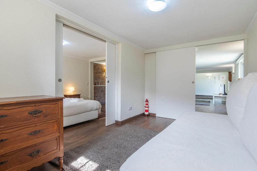 a bedroom with a bed and a dresser and a mirror at Kochab Sintra by LovelyStay in Sintra