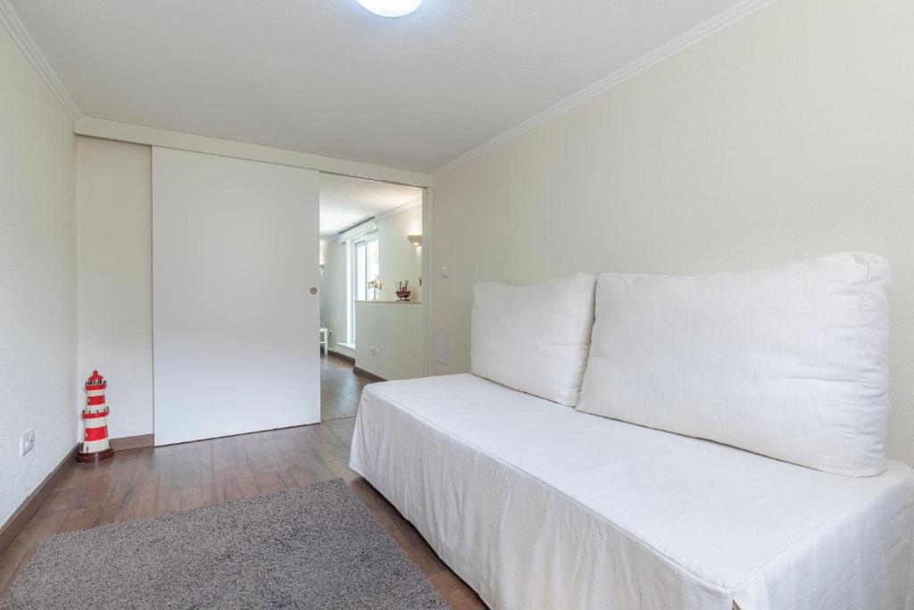 a white bedroom with a large bed with white pillows at Kochab Sintra by LovelyStay in Sintra