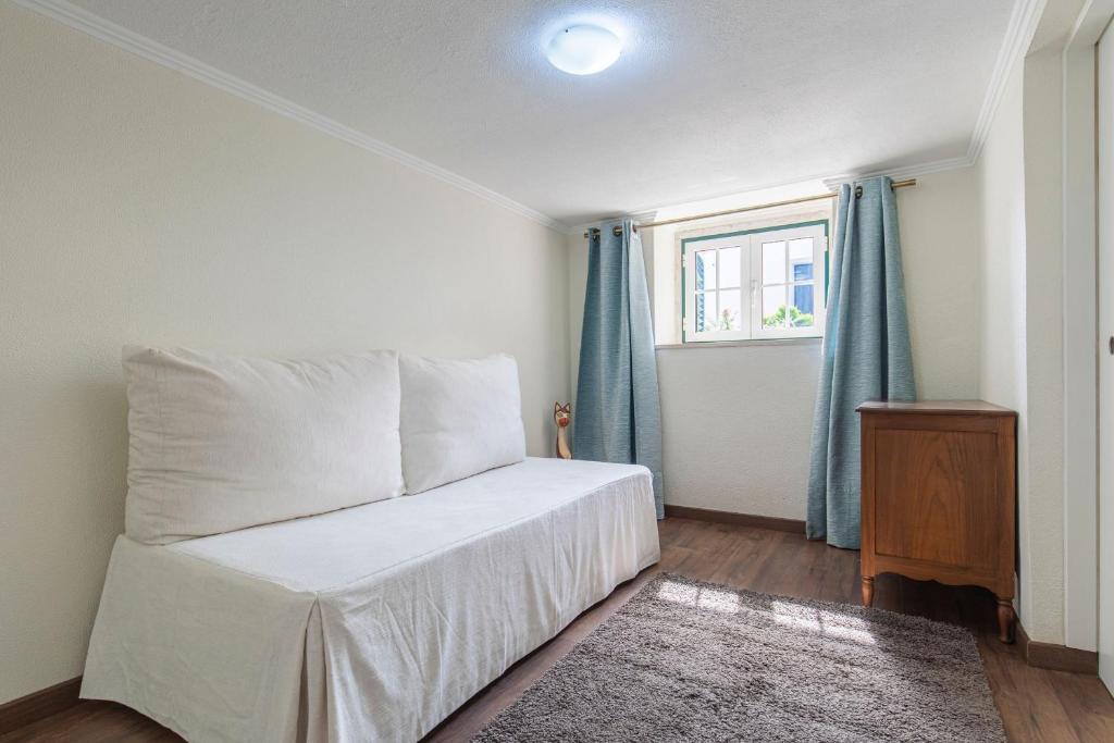 a bedroom with a bed with blue curtains and a window at Kochab Sintra by LovelyStay in Sintra