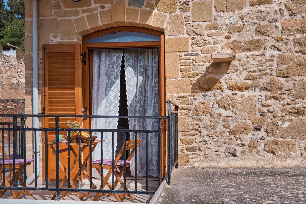 drzwi do budynku ze stołem i krzesłami w obiekcie Vaggelis Little Stone House w mieście Maredhianá