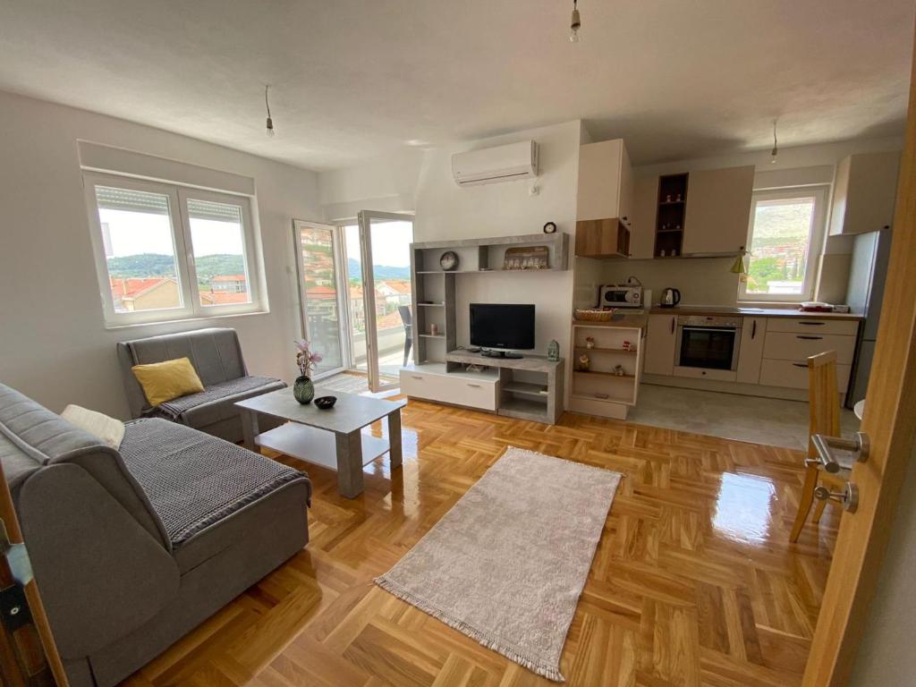 una sala de estar con un sofá y una mesa en Apartman Sunny Day, en Trebinje