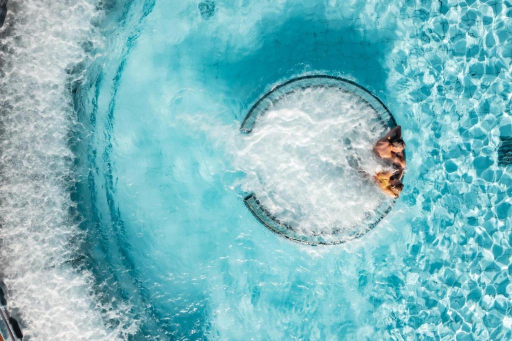 a person in the water in a swimming pool at De France by Thermalhotels in Leukerbad