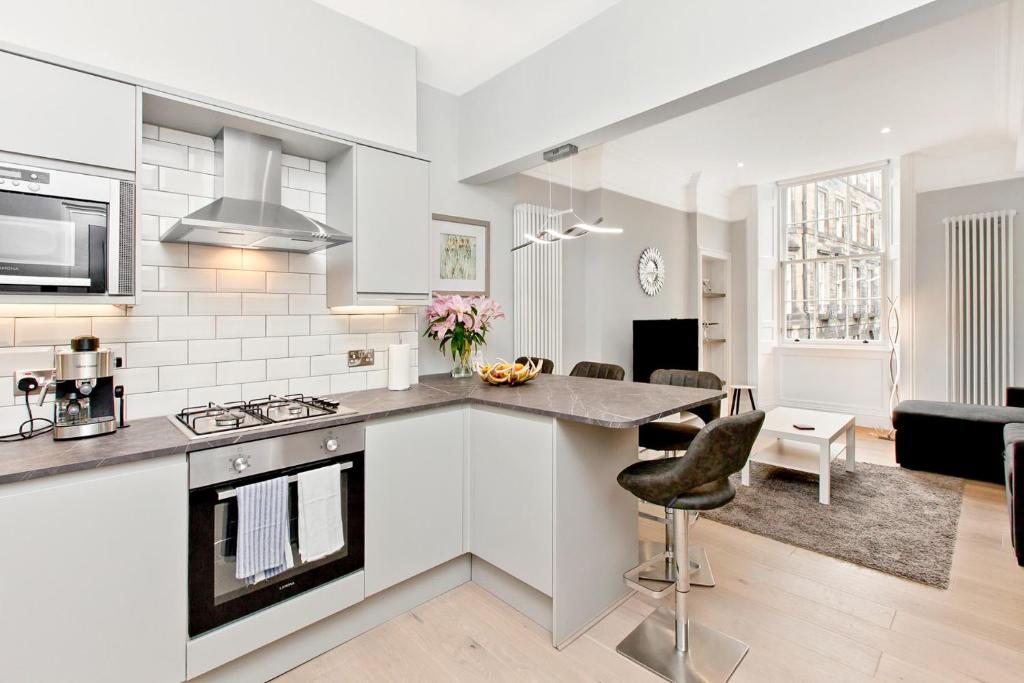 a kitchen and living room in a apartment at Modern & Spacious 1 Bed Apt, West End in Edinburgh