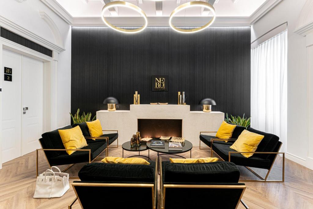 a living room with black and yellow pillows and a fireplace at Nero Luxury Suites in Cagliari