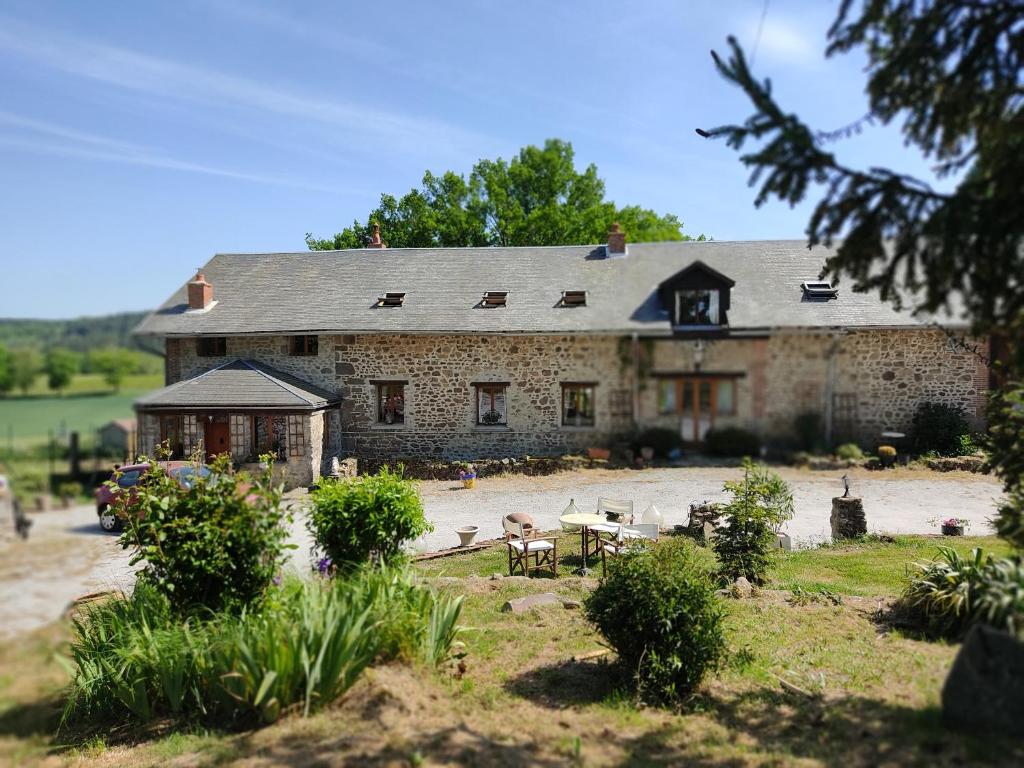 a large stone house with a table and chairs at Les quatre vents in Ars