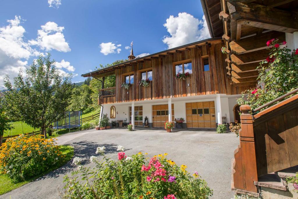 a large wooden house with flowers in front of it at Haus Rendl 1 in Bramberg am Wildkogel