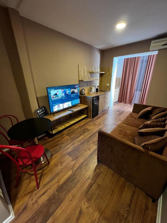 Il comprend un salon doté d'un canapé et d'une télévision à écran plat. dans l'établissement BejartApartment2, à Tirana