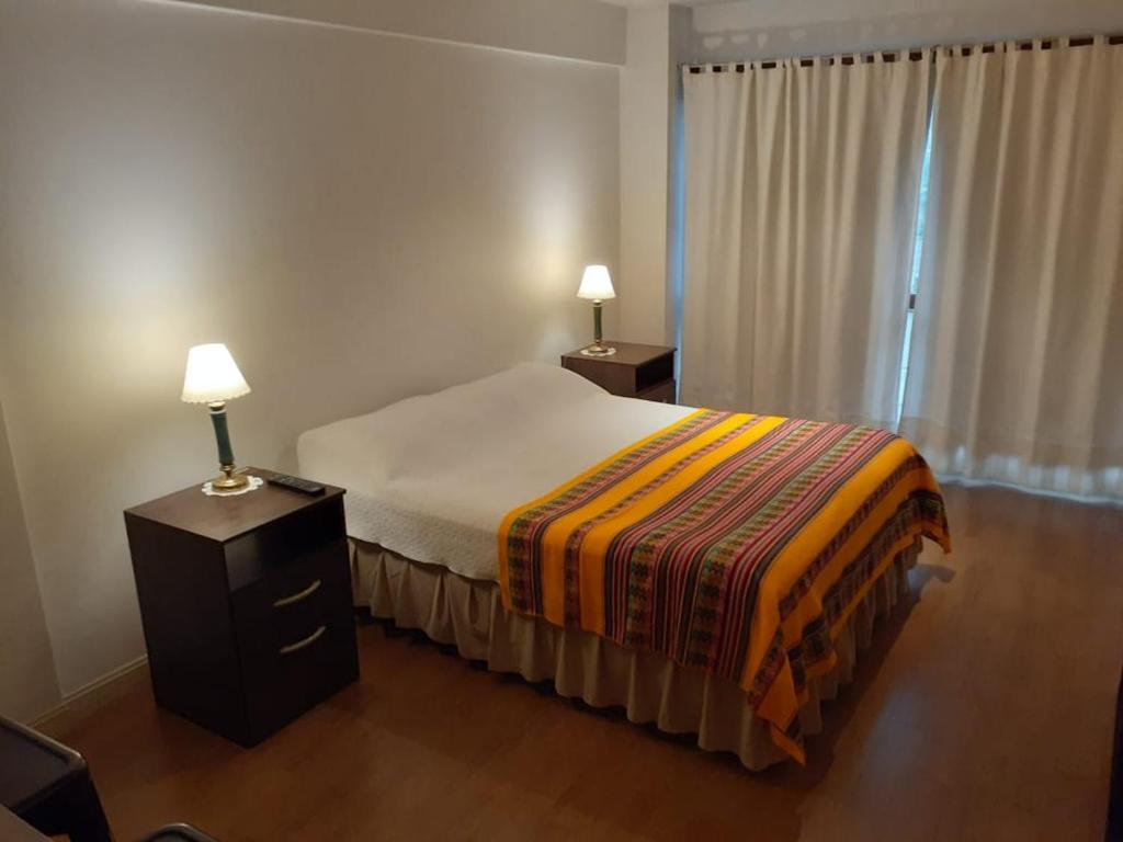 um quarto com uma cama e uma mesa de cabeceira com 2 candeeiros em Terra1 em San Carlos de Bariloche
