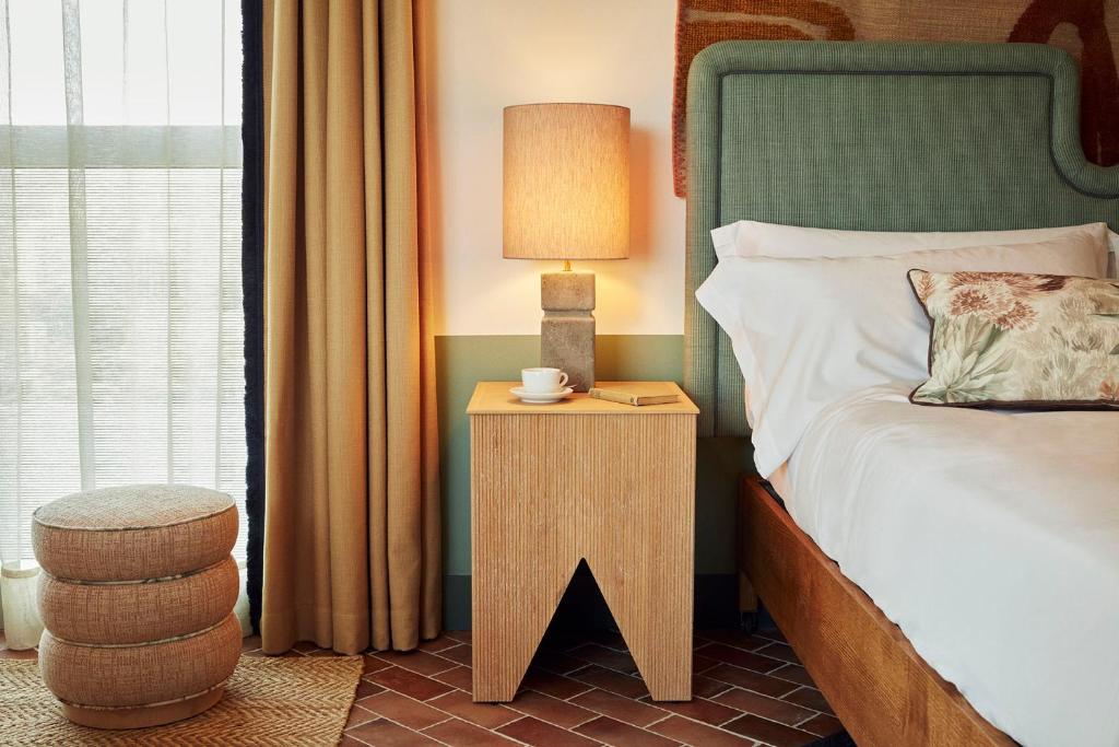 a bedroom with a bed and a table with a lamp at The Hoxton, Poblenou in Barcelona