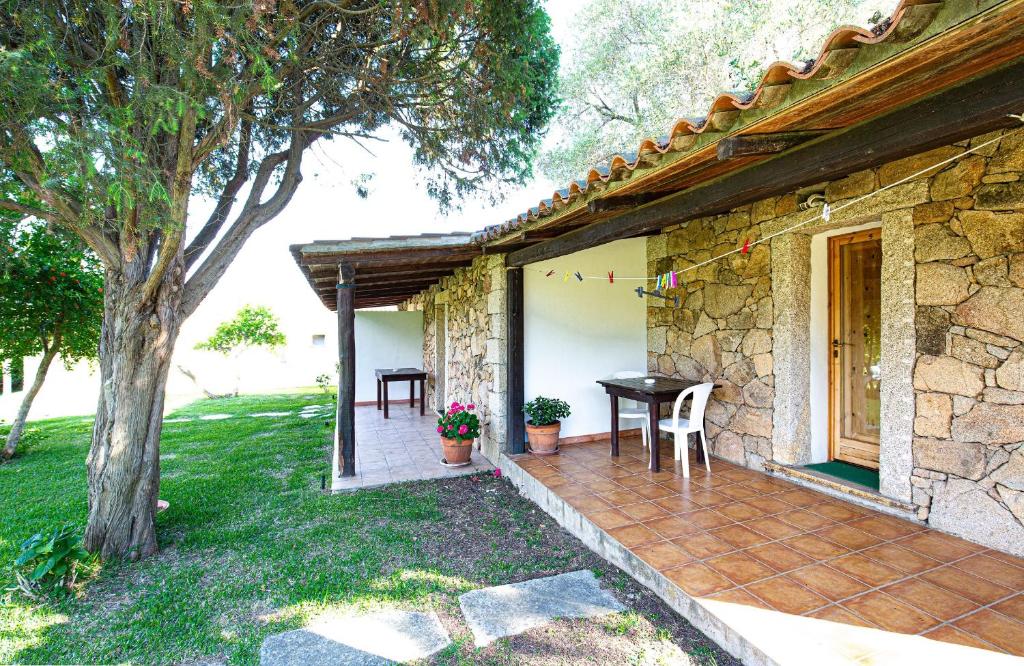 un patio di una casa con tavolo e albero di Turismo Rurale CUDACCIOLU a Arzachena