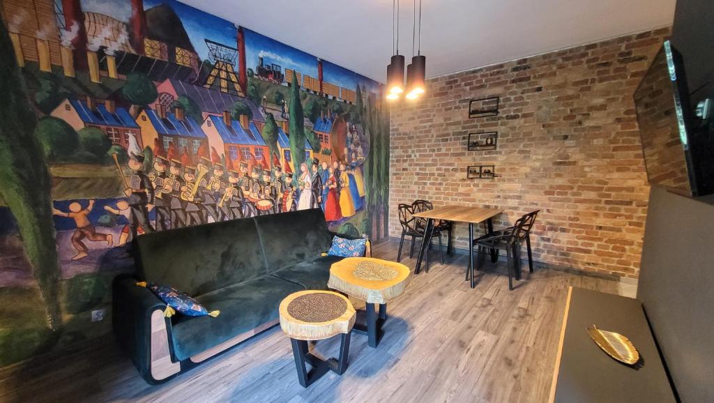 a living room with a couch and a table at Apartament Złote Żdżadło Nikiszowiec in Katowice
