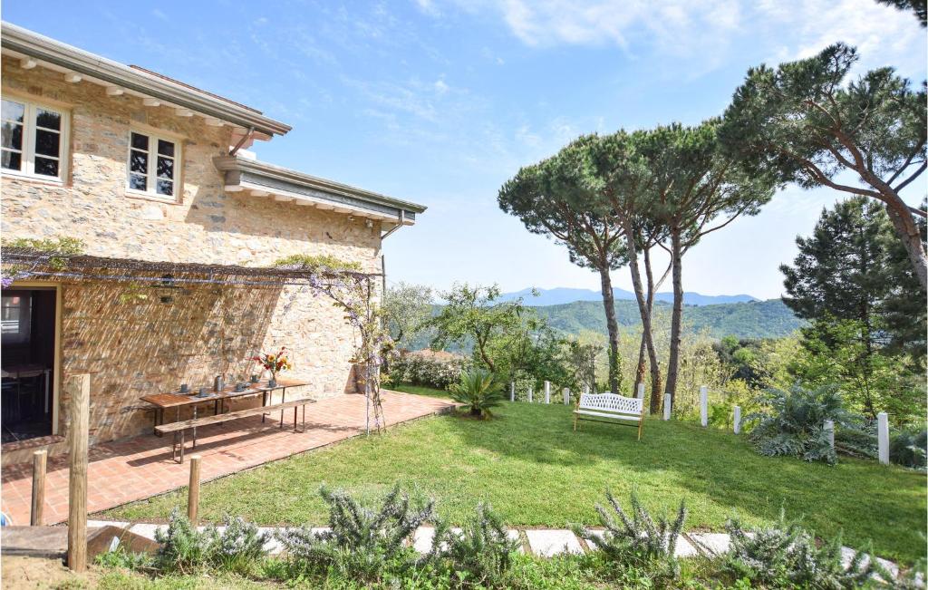 a garden with a bench and a building at Lovely Home In Santa Maria Albiano in Santa Maria Albiano