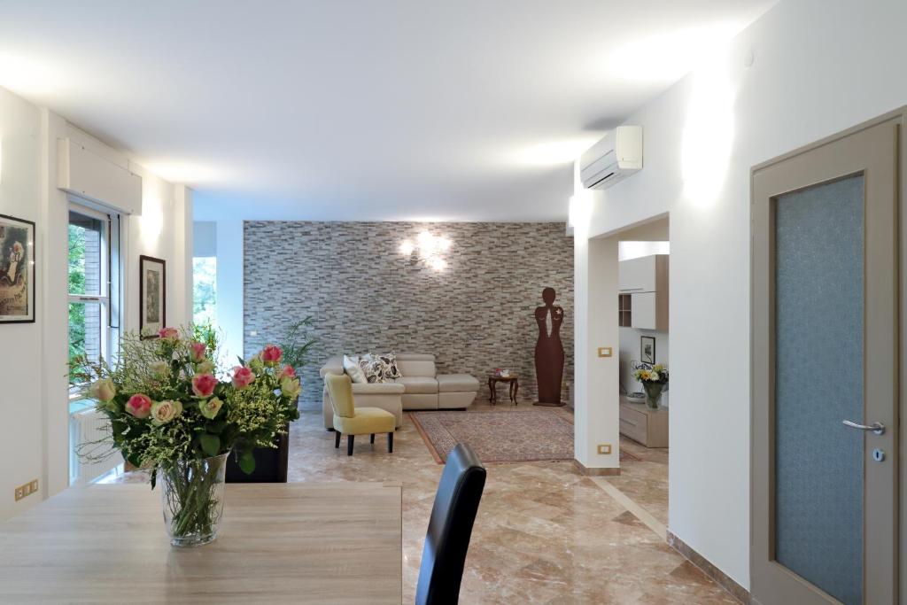a living room with a table with a vase of flowers at PadovaResidence Apartments - vicino Cappella degli Scrovegni, Ospedale e Università in Padova