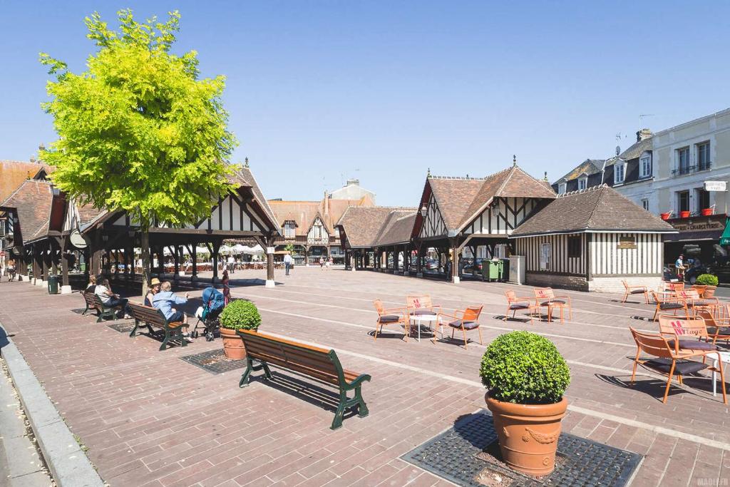 un grupo de personas sentadas en bancos en un patio en MAISON GAMBETTA en Deauville