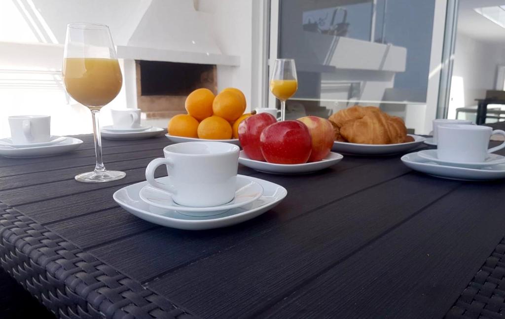 einen Holztisch mit Tassen Kaffee und Obst in der Unterkunft Vivienda Tauro in Puerto del Carmen