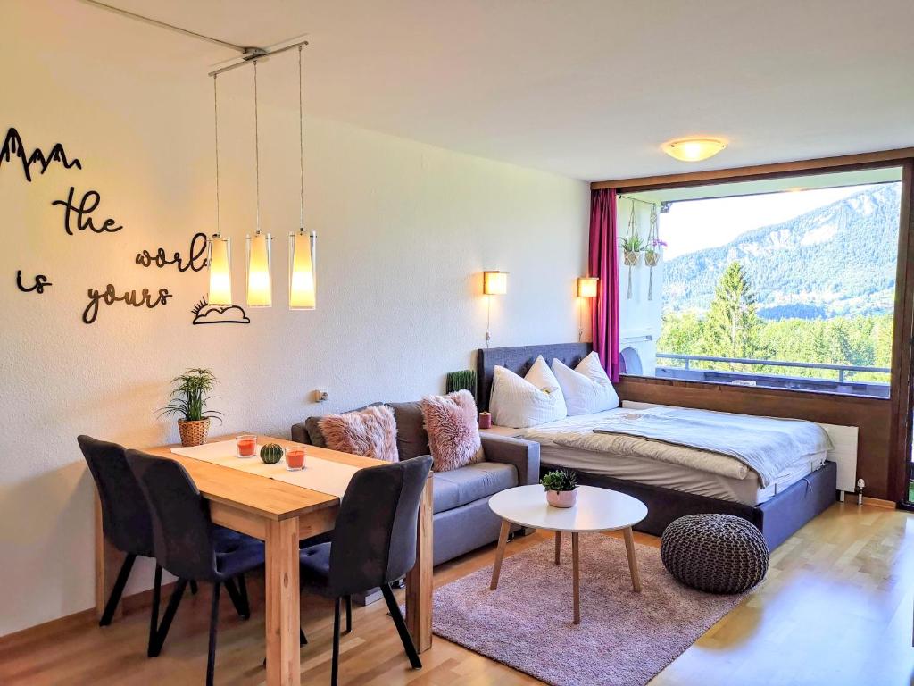 Jonas Deluxe Apartment Panoramablick في باد غويسرن: غرفة معيشة مع أريكة وطاولة وسرير