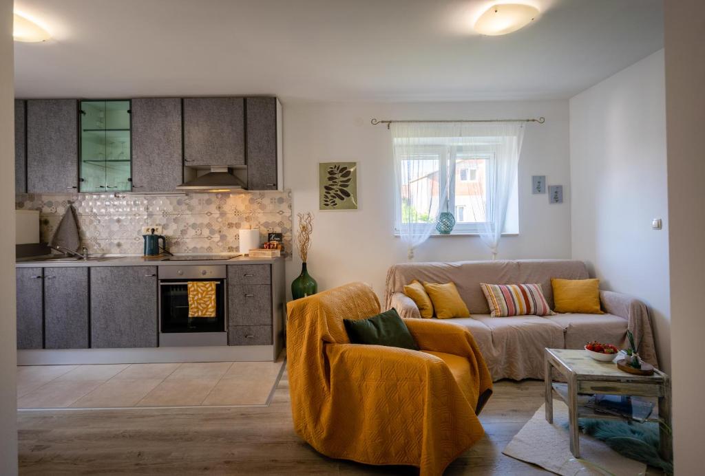 a living room with a couch and a kitchen at Apartman Tina in Metković