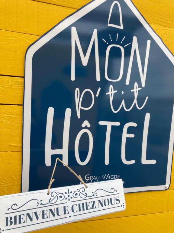 a sign for a mom t hotel hanging on a wall at Mon P'tit Hôtel in Le Grau-dʼAgde