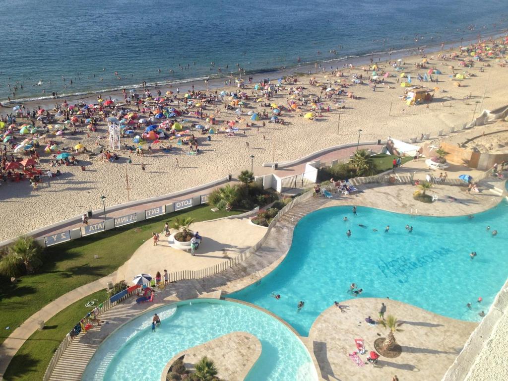 uma vista aérea de uma praia com pessoas e uma piscina em Departamento Playa La Herradura em Coquimbo