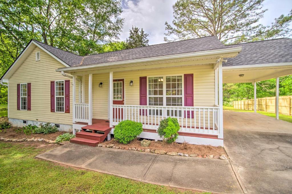una pequeña casa amarilla con porche en Cartersville Family Home with Spacious Backyard, en Cartersville