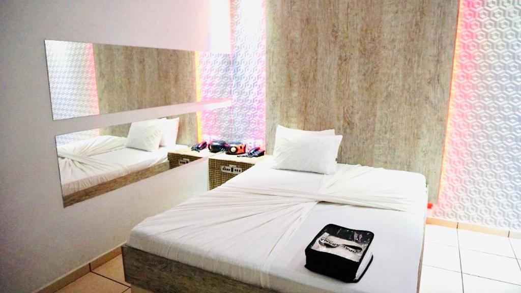 a bedroom with a white bed and a mirror at Motel Copacabana Cafe in Ribeirão Preto