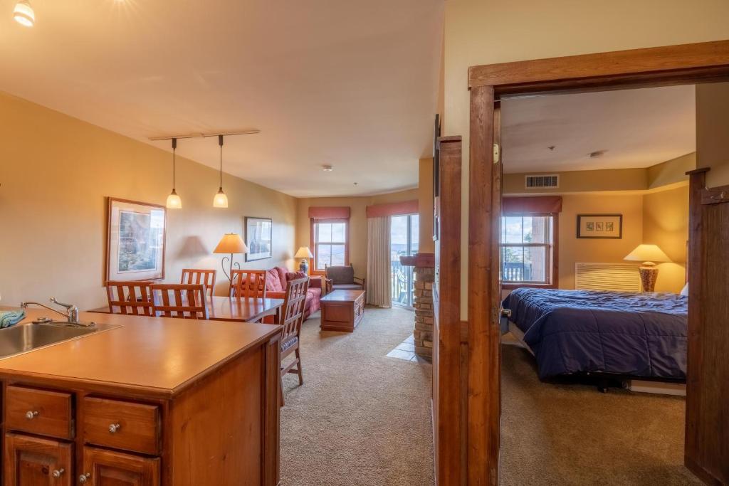 eine Küche und ein Wohnzimmer mit einem Schlafzimmer und einem Bett in der Unterkunft Highland House 207 Slopeside, Village Area, Ski in out in Snowshoe