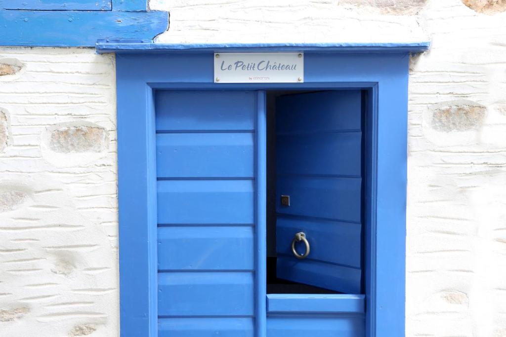 Niebieskie drzwi z napisem "Wynająłem Chicago" w obiekcie Le petit château w mieście Ano Syros