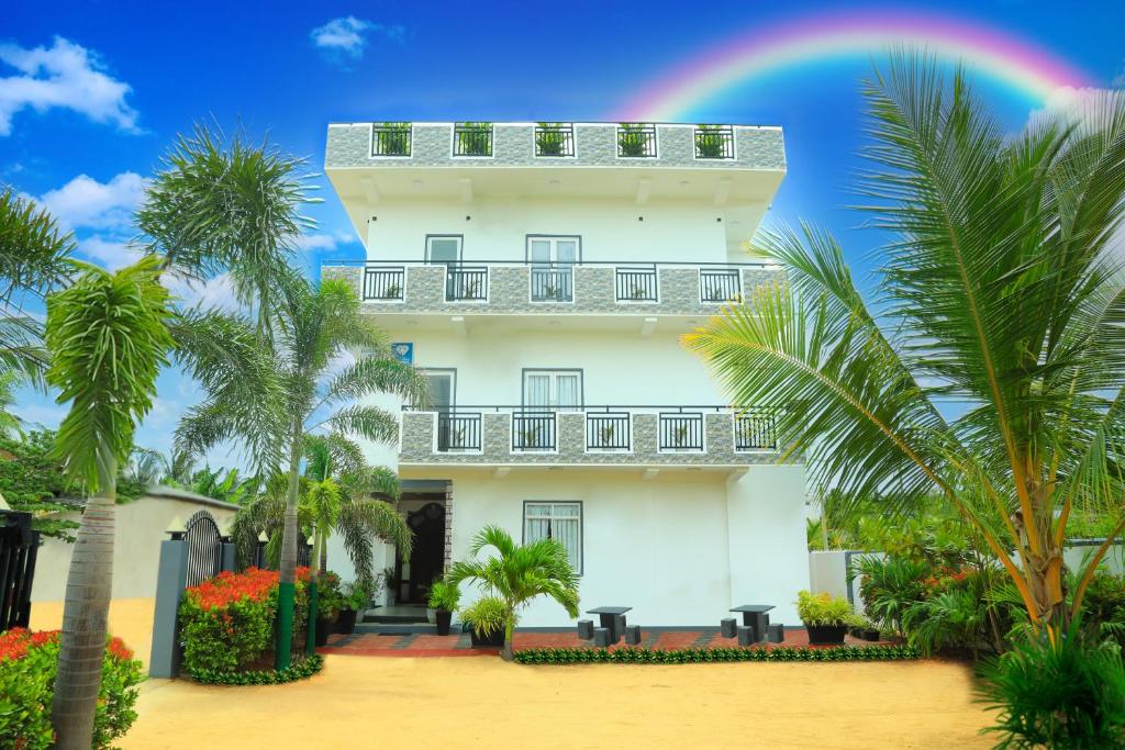 un gran edificio blanco con un arco iris en el cielo en Blue Diamond Resort en Trincomalee