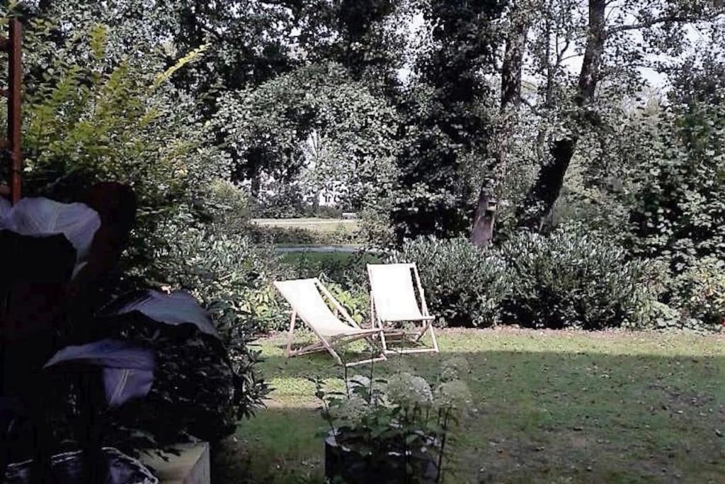 two white chairs sitting in the grass in a garden at Schickes Wohnstudio mit Garten am Aasee in Ibbenbüren