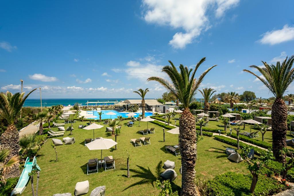 Blick auf ein Resort mit Pool und Palmen in der Unterkunft Marinos Beach Hotel in Platanes