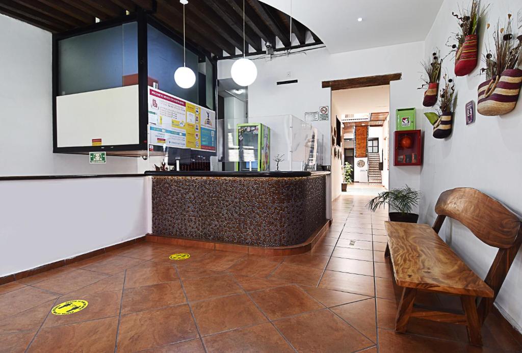 a restaurant with a counter and a bench in a room at Mexico City Hostel in Mexico City