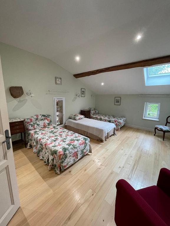 une grande chambre avec deux lits et un canapé dans l'établissement LA FERME DE VILLENEUVE, à Saint-Antoine