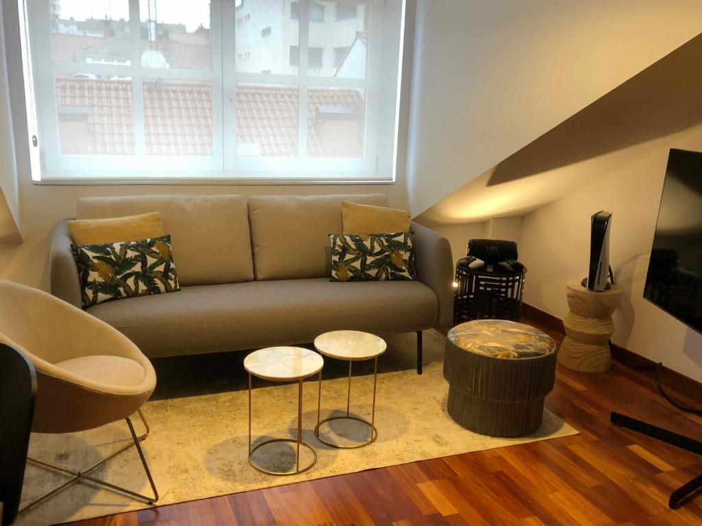 ein Wohnzimmer mit einem Sofa und 2 Tischen in der Unterkunft Yuhom casas con alma Galera 4º in A Coruña