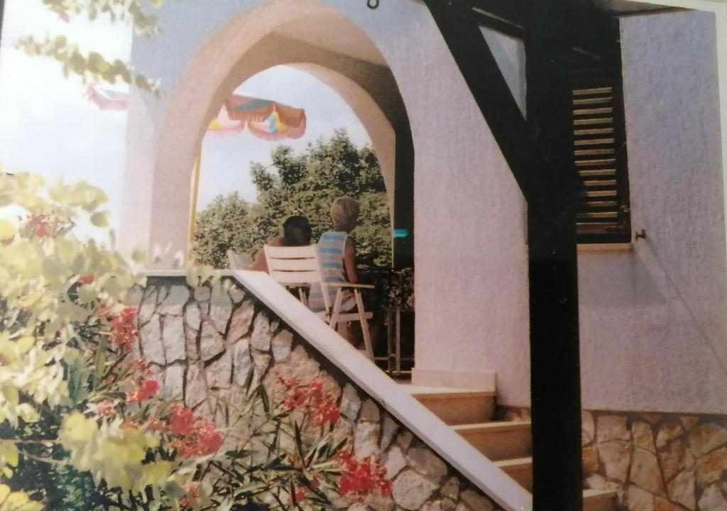 a couple sitting on the porch of a house at Haus Convallaria in Pinezici