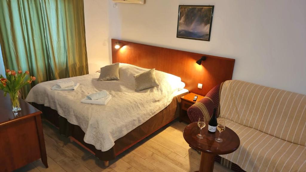 a hotel room with a bed and a couch at Restaurant &amp; rooms Visovac - best value in Skradin