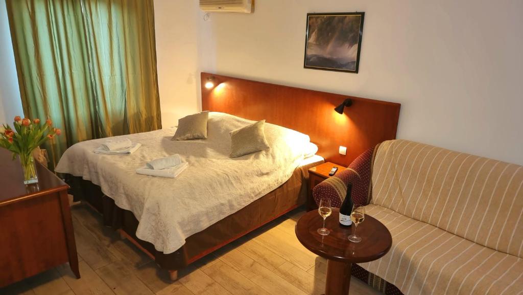 a hotel room with a bed and a couch at Restaurant &amp; rooms Visovac - best value in Skradin