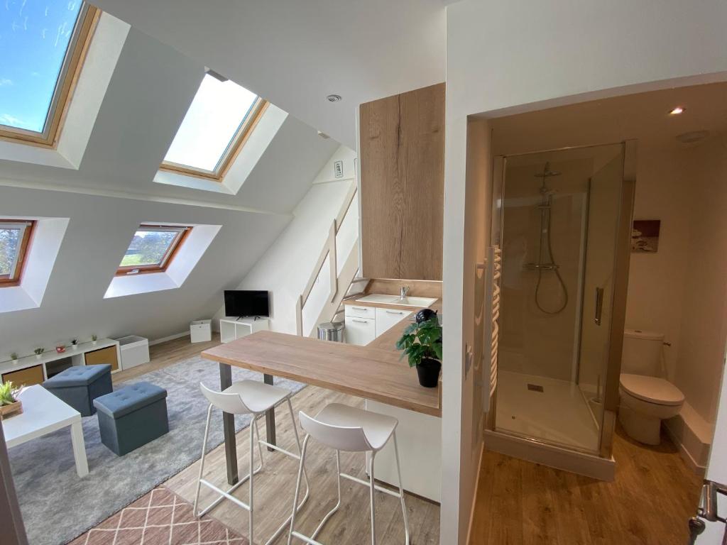 uma cozinha com uma mesa e cadeiras num sótão em studio duplex - Bord de mer em Ouistreham