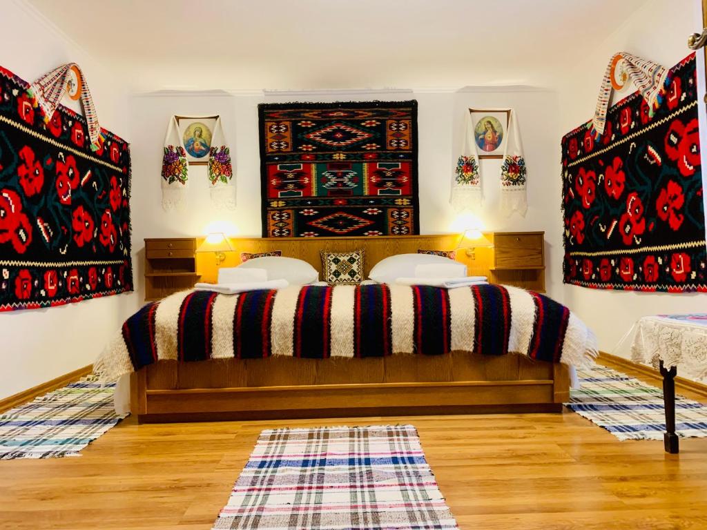 a bedroom with a bed with red and black blankets at ILEANA Săpânța in Săpânța